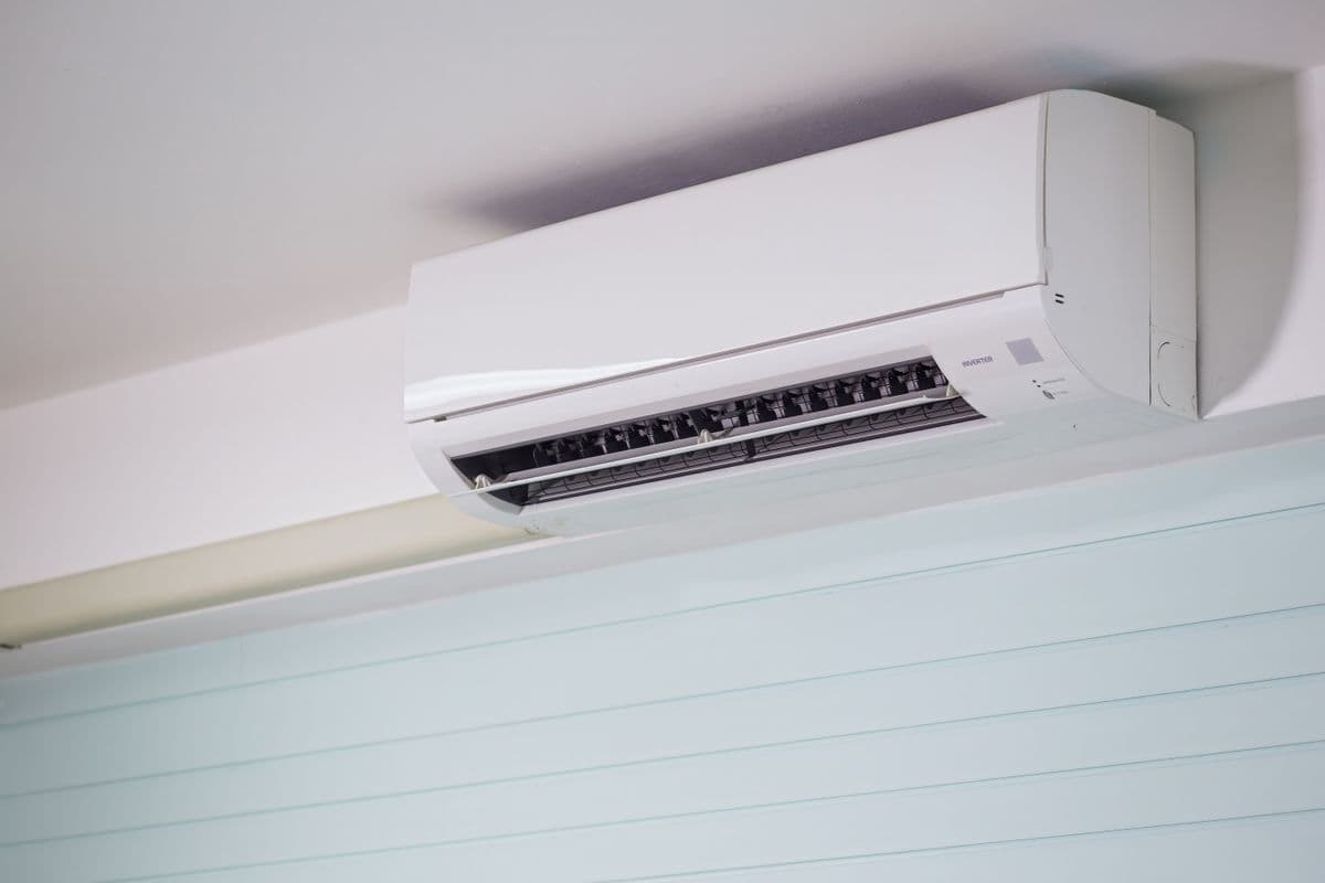 A white wall-mounted split air conditioning unit above a window